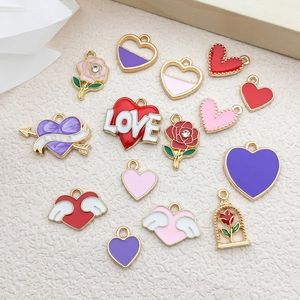 Macro view of assorted heart and rose enamel alloy charms with gold finish for DIY crafts