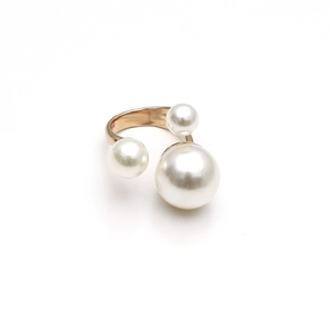 Elegant gold metal ring featuring three white pearls of varying sizes on white background
