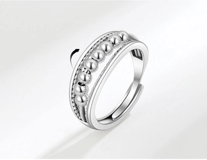 Close-up of adjustable silver ring with rotating beads and braided texture design