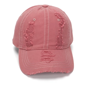 Detailansicht der Löcher im Used-Look und Baumwolltextur einer rosa Baseballkappe