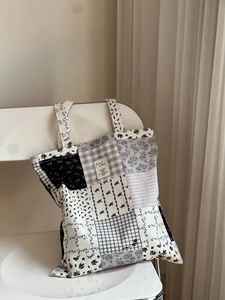 Close-up of patchwork floral canvas tote bag hanging on white minimalist chair