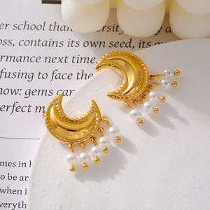 Chic gold moon earrings with faux pearls and fringe detail on minimalist stone base