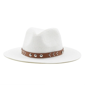 Close-up of white straw fedora featuring brown leather band with silver rivets and metal accents