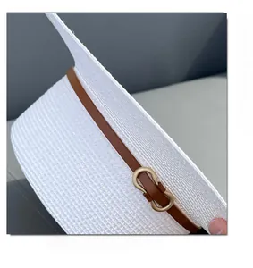 Close-up of white boater hat with fine weave, brown leather band and gold buckle detail