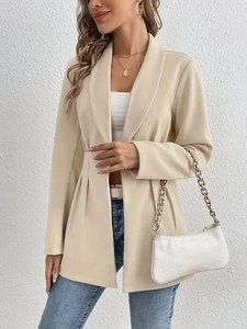 Détail d'un blazer élégant abricot avec revers crantés et design plissé à la taille