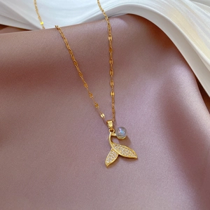 Titanium steel fishtail necklace with gold plating and sparkling crystals on silk background