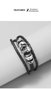 Detail of multi-layer black braided leather bracelet featuring a vintage metal skull charm