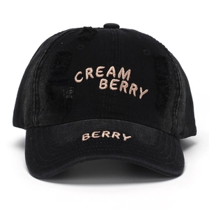 Distressed black denim baseball cap with gold Cream Berry embroidery and ripped details