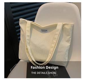 Detail shot of off-white corduroy tote bag showing ribbed texture and fashion label