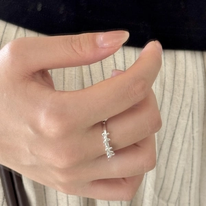 Close-up of S925 sterling silver bow knot ring on hand with elegant floral design detail