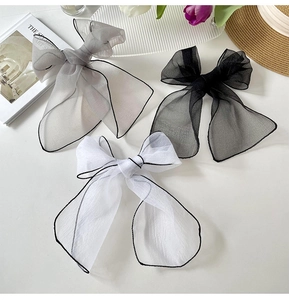 Detailed view of oversized sheer organza bow hair clips in grey, black and white colors