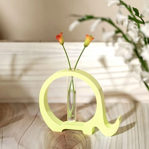 Detail of elephant-shaped hydroponic vase with glass tube on wooden surface