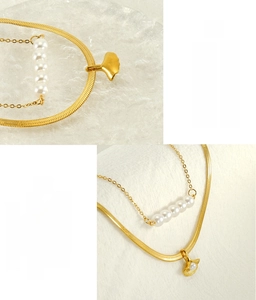 Detail of double-layer stainless steel necklace featuring ginkgo leaf and five pearls