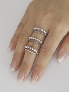 Gros plan sur un ensemble de bagues doubles en acier avec perles et zircons colorés