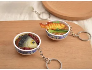 Close-up of miniature PVC food keychains with realistic dishes in blue and white bowls
