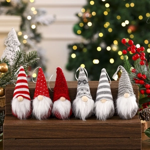 Close-up of six knitted Christmas gnomes with long plush beards on a wooden base