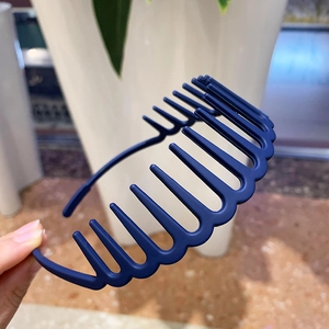 Detail of matte dark blue headband with teeth for secure grip and voluminous hairstyle