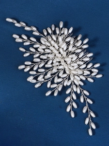 Detail of handcrafted silver bridal hair comb with elegant white pearls and floral wires