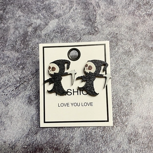Halloween Reaper earrings featuring a skeleton with scythe on dark stone background