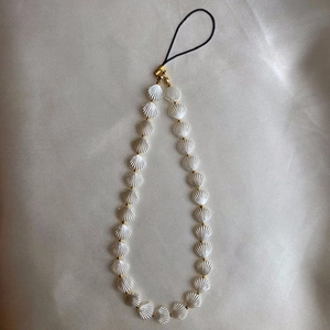 Minimalist beaded phone strap featuring white shell charms and golden metal accents