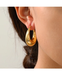 Close-up of polished 14K gold plated teardrop earring worn by a model in detail