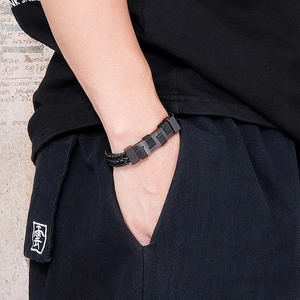 Close-up of black woven titanium steel bracelet on male wrist for a hip hop rock style