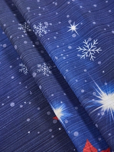 Detailed close-up of blue fabric texture with white snowflake patterns and red star accents