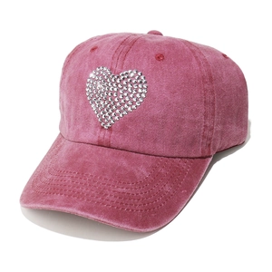 Detail of rose red washed cotton baseball cap featuring a sparkling rhinestone heart