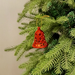 Rote Metall-Weihnachtsglocken mit Stern-Ausschnitten am grünen Weihnachtsbaum