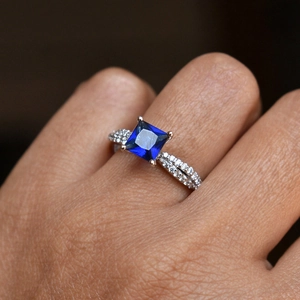 Δαχτυλίδι με μπλε βασιλικό λίθο princess cut και σταυρωτή ασημένια ταινία pavé