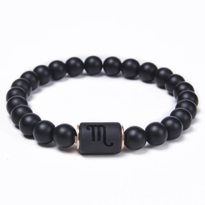 Macro shot of Scorpio black onyx beaded bracelet with engraved sign and bronze metal rings