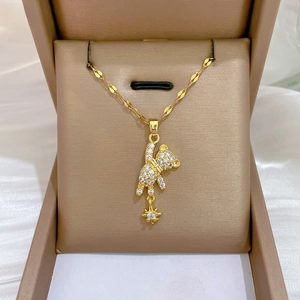 Detail of bear pendant with white zircons and star on golden faceted wave chain