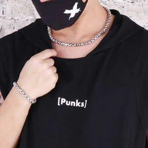 Neutral style silver stainless steel link necklace and bracelet set worn by a model
