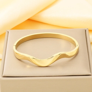 Bracelet jonc ondulé en acier inoxydable plaqué or 18 carats sur un socle en soie