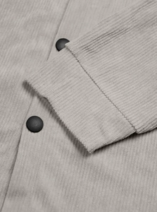 Detailed close-up of grey corduroy sleeve texture and matte black buttons on a work jacket