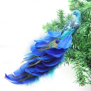 Décoration de Noël paon bleu avec paillettes et plumes naturelles sur une branche de sapin