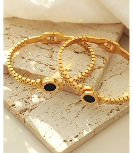 Dettaglio del bracciale placcato oro 18K con disco nero e incisione di numeri romani