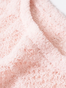 Macro d'un tissu en maille rose doux avec une texture pelucheuse et un motif floral