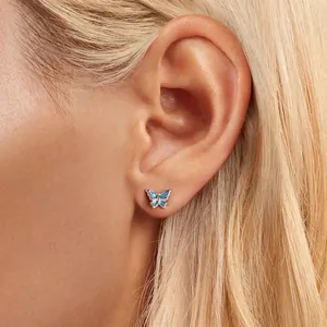Elegant butterfly stud earrings in s925 sterling silver with blue enamel on a female model