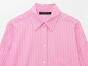 Detail of pink and white striped shirt collar, front pocket and white button closure