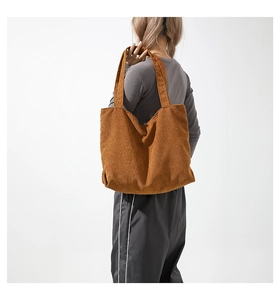 Brown corduroy tote bag showing large capacity and shoulder strap detail on model