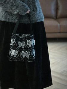 Close-up of vintage butterfly embroidery on a black canvas mini hobo shoulder bag