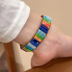 Détail macro d'un bracelet tressé coloré avec des perles de pierre rectangulaires arc-en-ciel