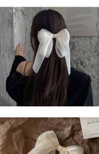 Detail of a large white organza bow hair clip for women shown on model and flat lay