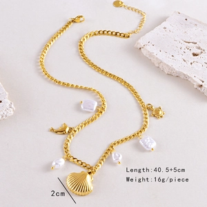 Detail of gold ocean necklace with pearls, seashell and dolphin charms on stone