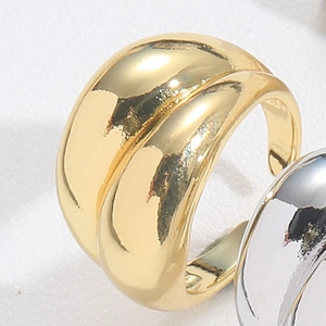 Macro view of gold-plated wide band ring featuring a polished double-layer wavy design