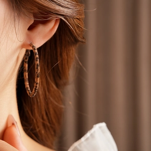 Close-up of leopard print fabric hoop earrings for women with a vintage aesthetic