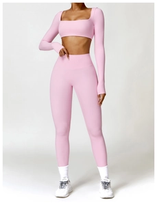 Detailed view of pink long-sleeved crop top and high-waisted leggings set on a model