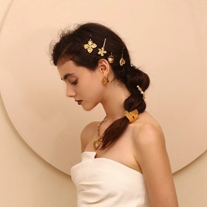 Detailed view of 18K gold plated stainless steel heart hair clip worn by a model