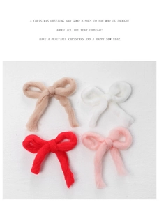 Detailed view of four handmade plush bow ornaments in beige, white, red, and pink colors